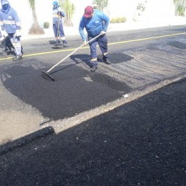 Na foto, destaque para a equipe de tapa-buracos realizando aplicação de massa asfáltica.