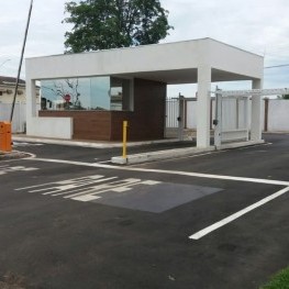 Na foto, guarita de entrada com pinturas de sinalização de solo