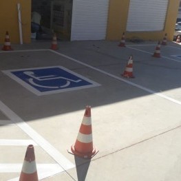 Na foto, pintura de sinalização de solo indicando local para cadeirantes