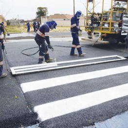 Na foto, funcionários da EMDEF realizam a pintura de sinalização da faixa de pedestres