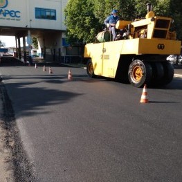 Na foto, maquinário da EMDEF utilizado para planar a massa asfáltica em uma rua sendo recapeada
